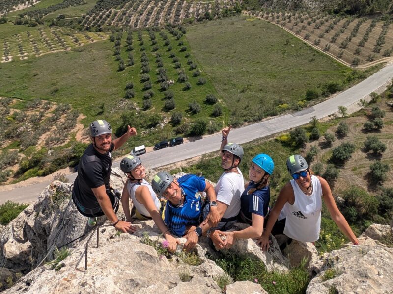 Grupo sonriente disfrutando de las vistas panorámicas en la Vía Ferrata de Moclín, Granada, con Takamaka Aventura.